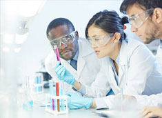 A diverse group of scientists in labcoats looking at a test tube